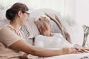 Elderly woman in hospital bed with social worker helping her