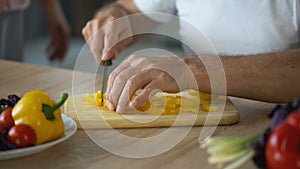 Elderly woman hugging husband, cooking healthy breakfast, fresh vegetables