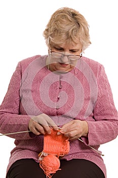 The elderly woman knits isolated on white