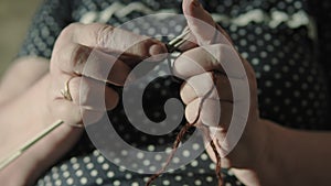 Elderly woman knitting at home