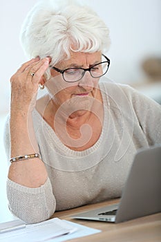 Elderly woman learning how to use laptop