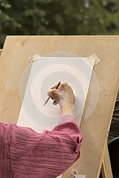 An elderly woman learns to draw in an art studio