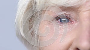 Elderly woman looking into camera, problems with eyes, blurry vision, cataracts