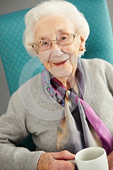Elderly woman looking comfortable drinking tea