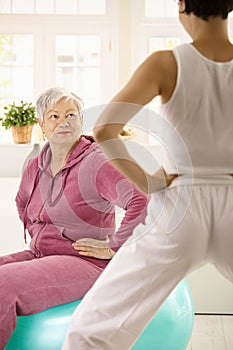 Elderly woman looking at personal trainer