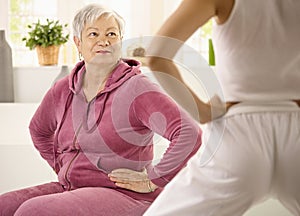 Elderly woman looking at personal trainer