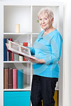 Elderly woman looking through photo album