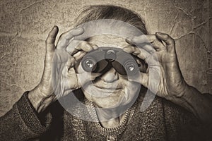 Elderly woman looks through binoculars.