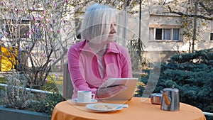 Elderly woman making breakfast outdoor using tablet - Slow motion