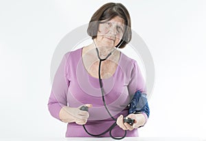 Elderly woman measuring arterial pressure.