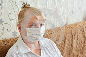 an elderly woman in a medical mask in quarantine and self-isolation, protecting the elderly from viruses and diseases