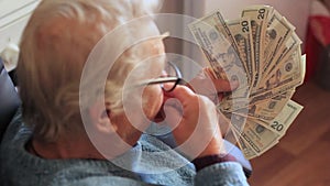 Elderly woman with money in her hands. Grandmother with dollars close-up