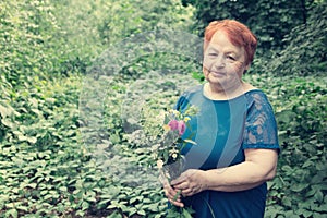 Elderly woman park flowers hands bouquet green nature