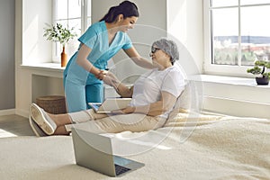 Elderly woman patient and female nurse talking in hospital or nursing home ward