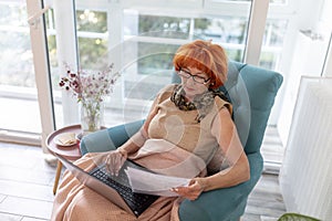 Elderly woman paying bills using laptop computer
