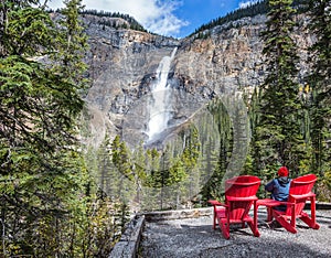 Elderly woman photographs the waterfall