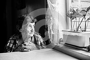 An elderly woman pining at the window. photo