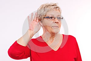 Elderly woman placing hand on ear, difficulty in hearing in old age