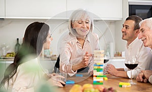 Elderly woman playing jenga with relatives during family gathering