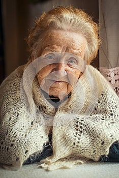 An elderly woman, a portrait sitting at the table.