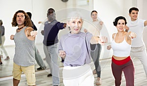 Elderly woman practicing punches during group self defense course