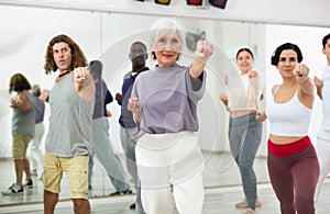 Elderly woman practicing punches during group self defense course