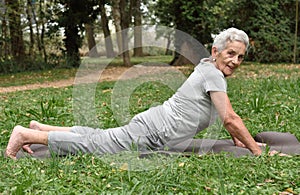 Elderly woman practicing yoga outdoors