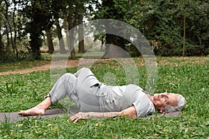 Elderly woman practicing yoga outdoors