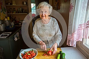 An elderly woman prepares a meal.