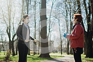 Elderly woman with protective face mask/gloves talking with a friend.Coronavirus COVID-19 disease protection.Conversation from a