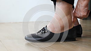 Elderly woman putting swollen feet on shoes
