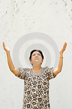 Elderly woman raising hands to worship