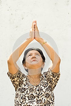 Elderly woman raising hands to worship