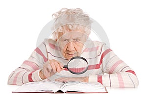 The elderly woman reads the book