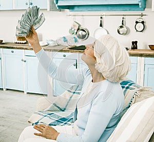 Elderly Woman Rejoices Holding Fan of Money in Her Hand