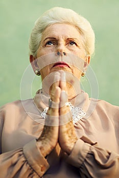 Portrait of serious old caucasian woman praying god photo