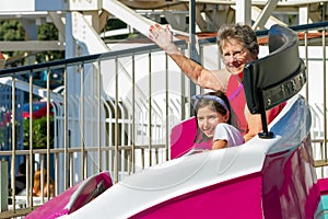 Elderly Woman Rides on a Tilting Spinning Ride at a Theme Park W