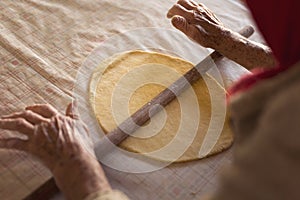 Elderly woman rolling out dough