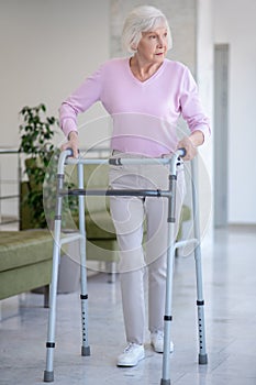 Elderly woman with a rolling-walker looking serious