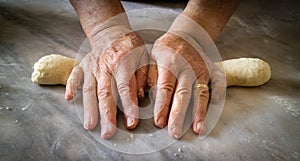 Elderly woman`s hands kneading dough to make fresh bio italian pasta