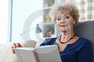 Elderly woman self-isolation reading book at home