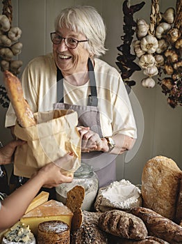 Elderly woman selling bread at a deli