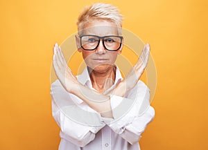 elderly woman with short gray hair wearing casual style rejection expression crossing arms doing negative sign