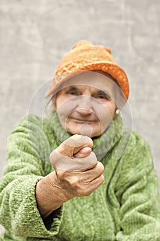 Elderly woman showing fig sign.