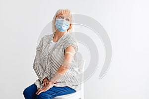 Elderly Woman Showing Vaccinated Arm After Antiviral Injection, White Studio