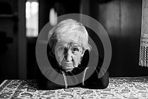 Elderly woman sitting in a dark room.
