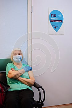 Elderly woman sitting at the doctor`s office after vaccination