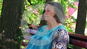 Elderly woman sitting on park bench