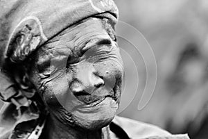 An elderly woman smiles with sadness and modesty in Gulu, Uganda