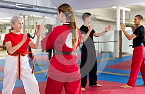 Elderly woman sparring with girl during martial arts training